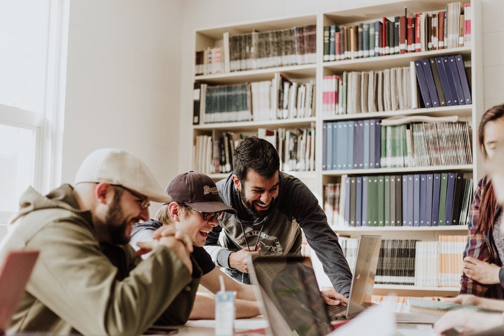 An image of three employees at a computer. Generation Z and Millennials favor work environments where they can have fun.