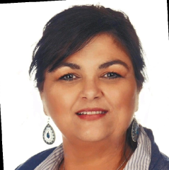 A woman with short dark hair and wearing drop earrings smiles at the camera against a plain white background.
